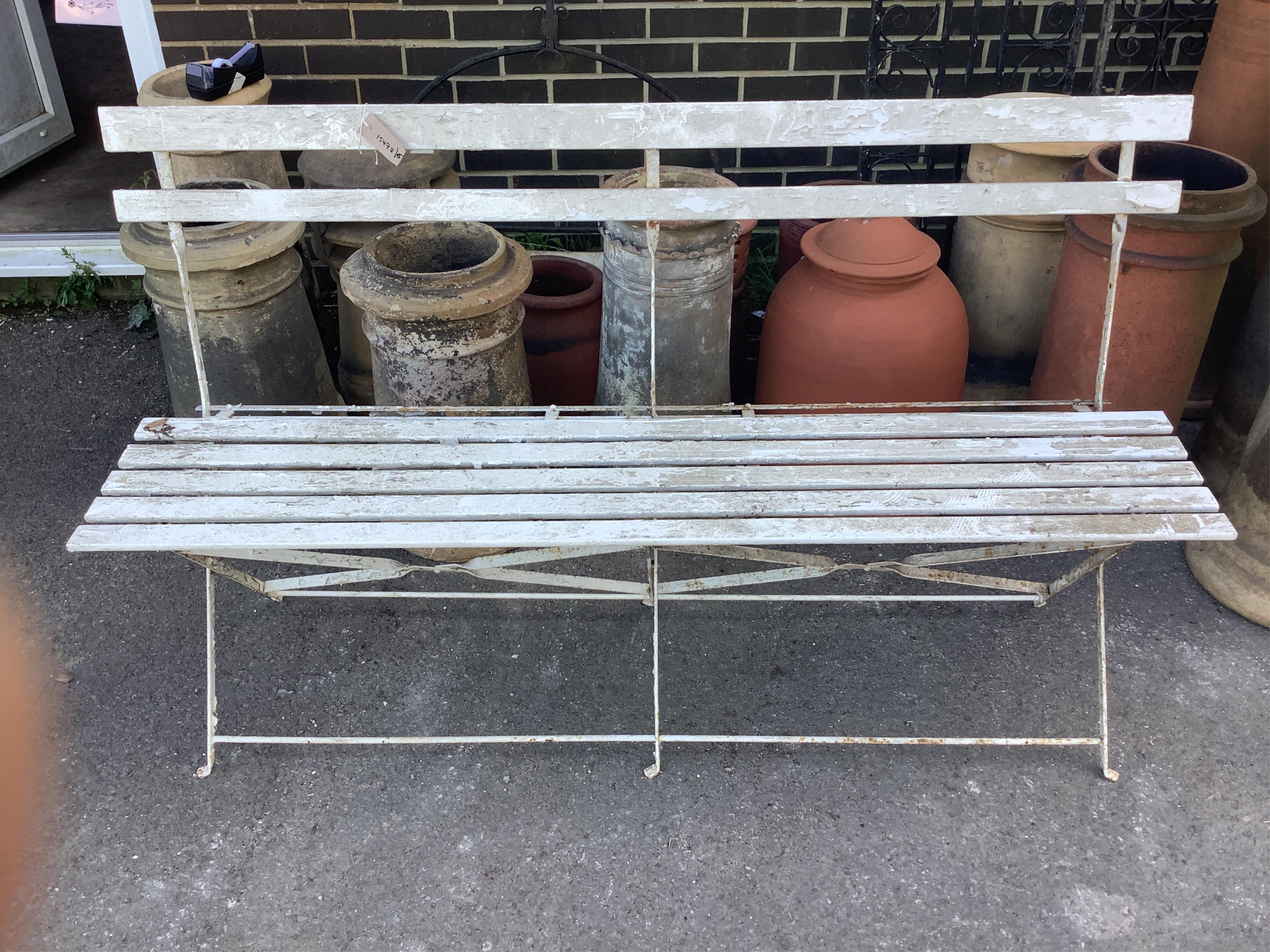 A vintage slatted wood and wrought iron garden bench, width 150cm, height 88cm. Condition - fair